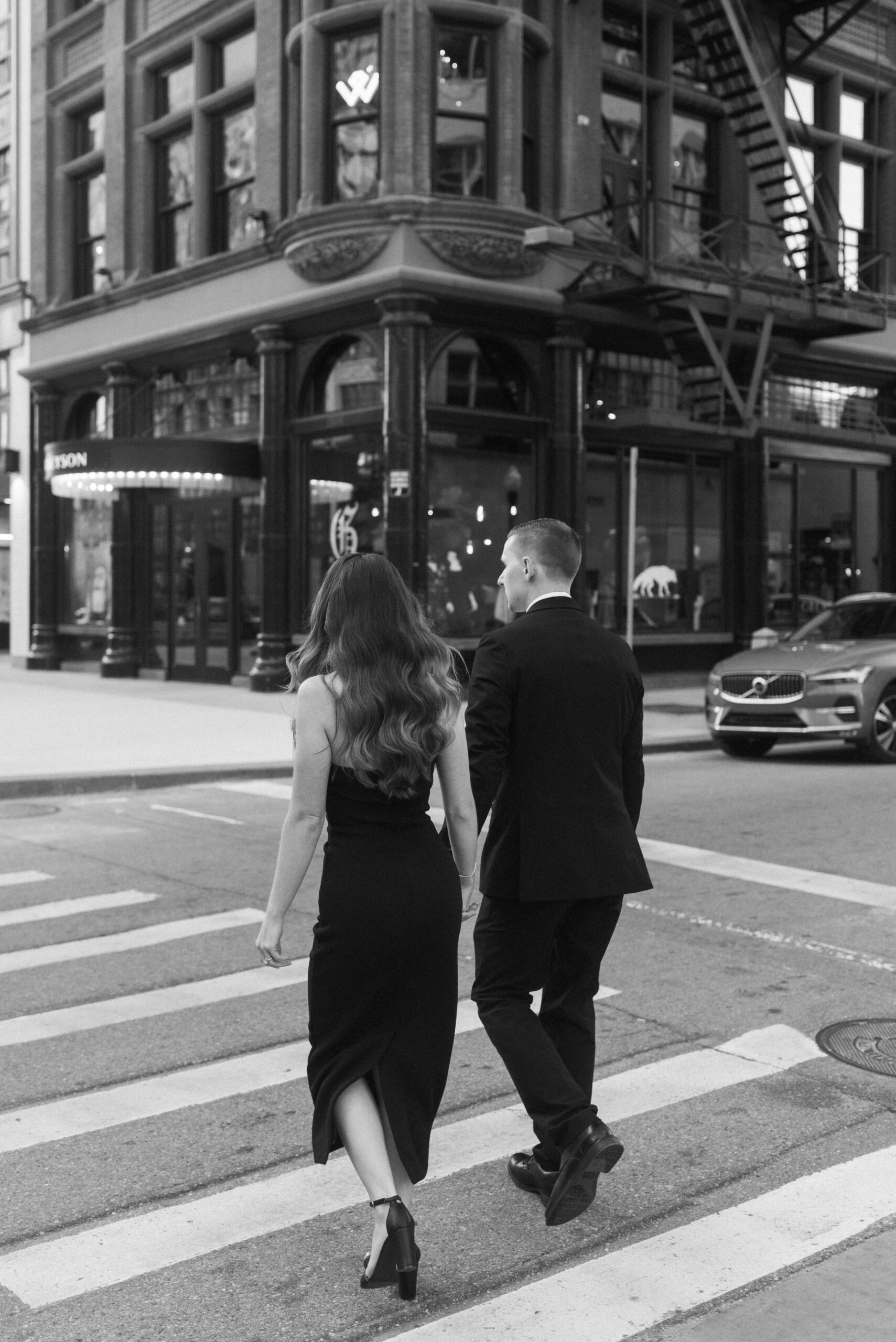 Couple walking across street in downtown Detroit for their Engagement session
