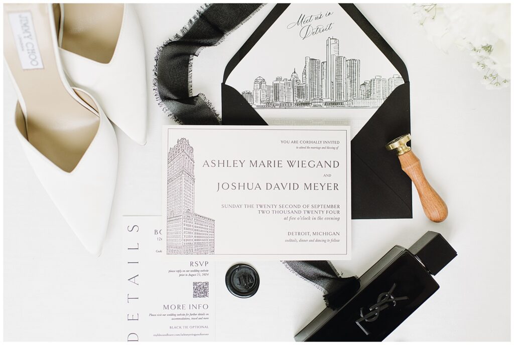 Wedding invitation set with shoes and cologne at the book tower