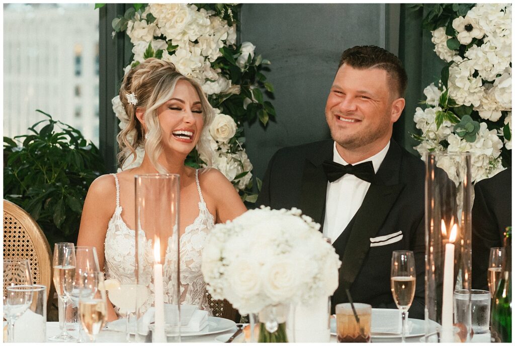 Bride and groom laughing during reception at book tower