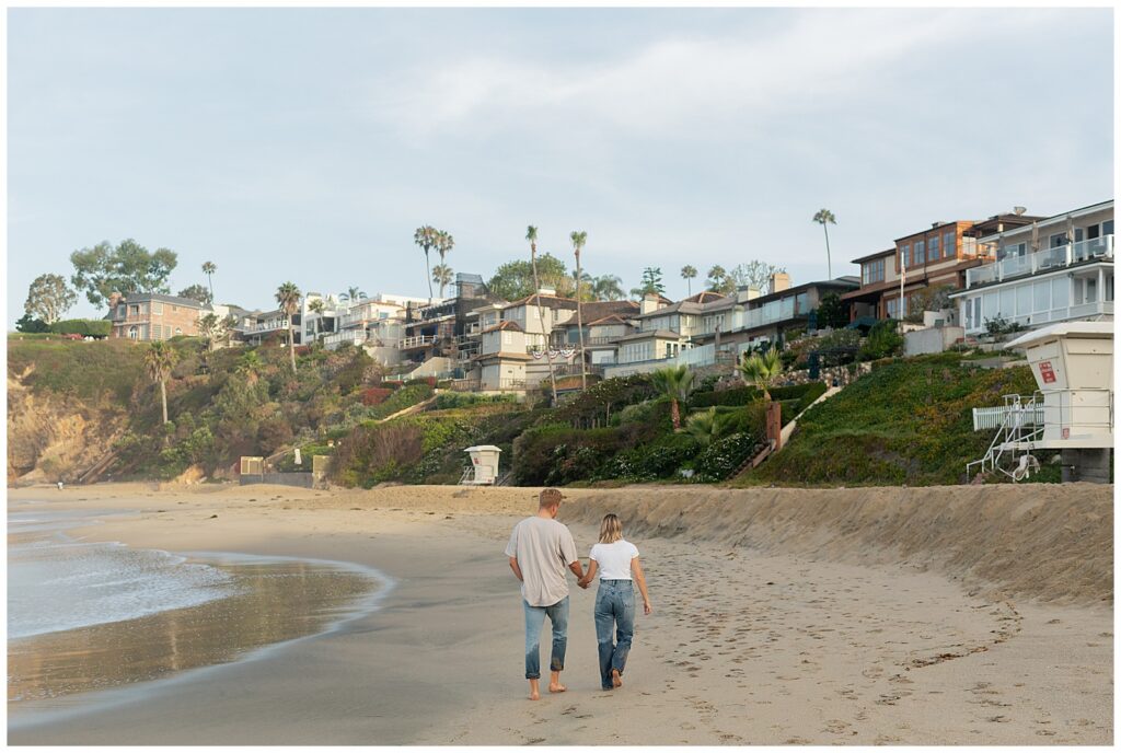 An image of couple on the beach walking away
